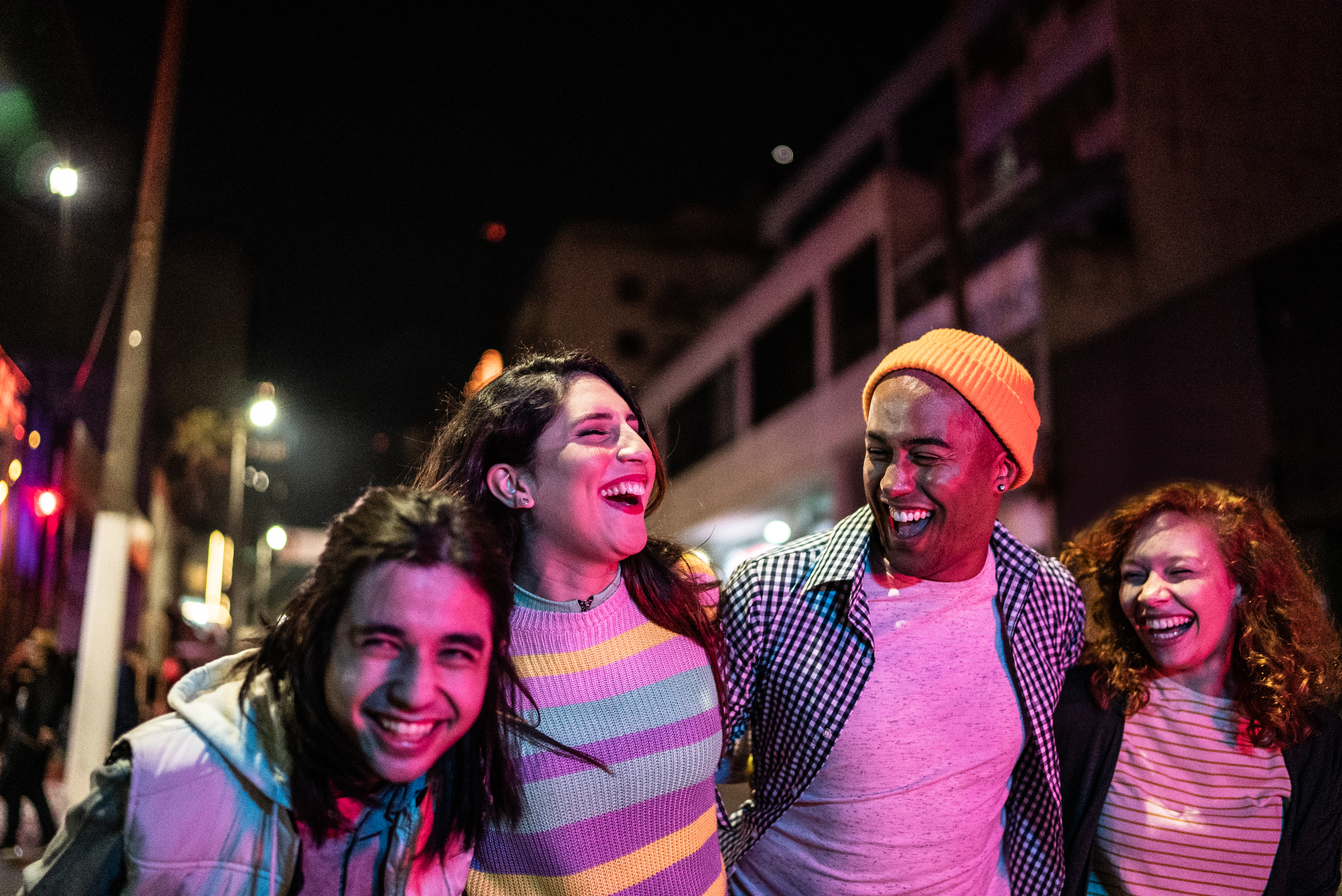 Group of friends laughing together at night